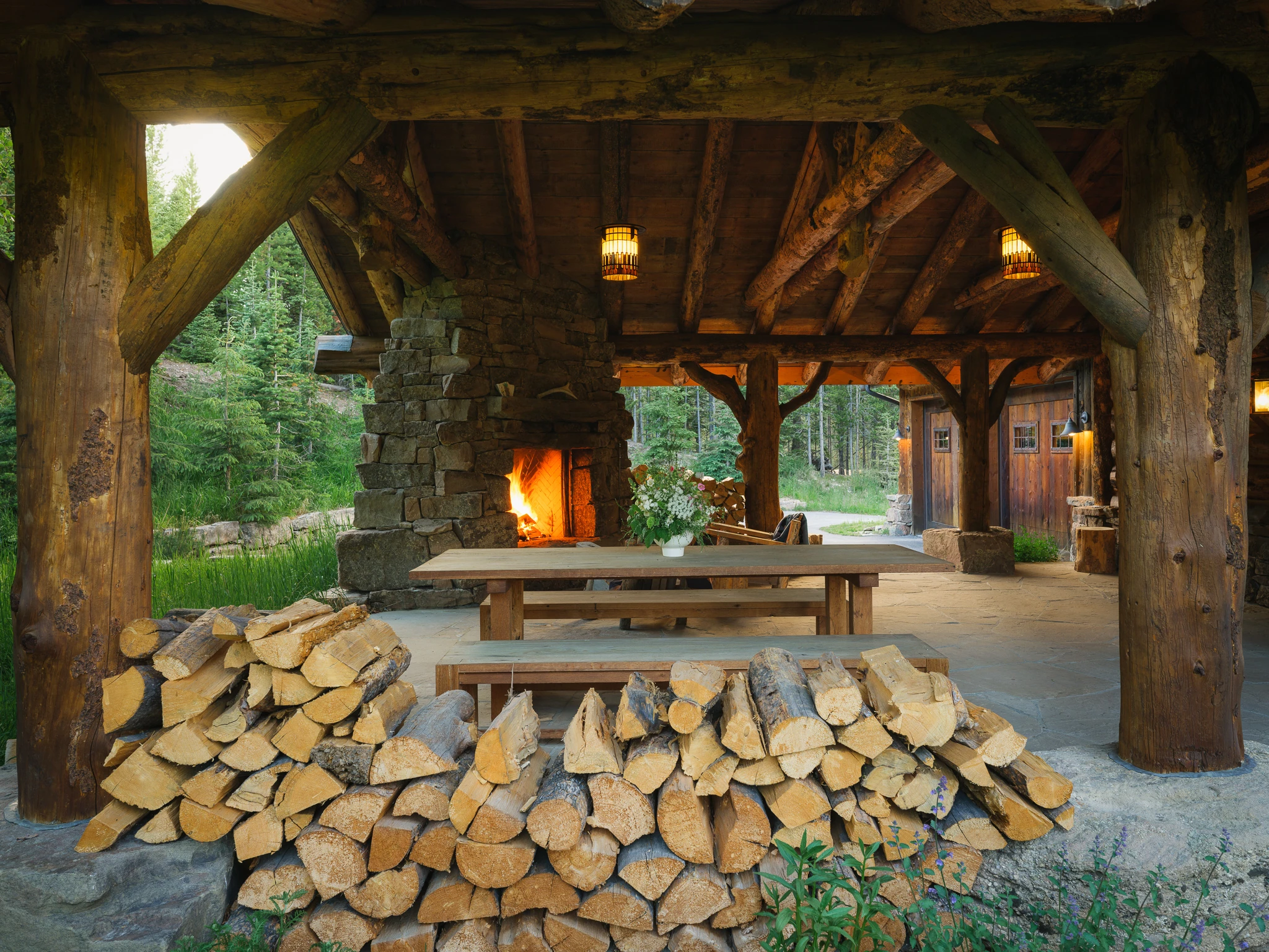 Covered outdoor dining pavilion with stone fireplace — architectural photography Big Sky Montana, Lohss Construction